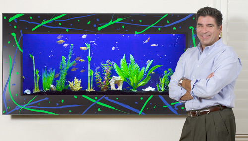 Founder and CEO Mark McGrath next to aquarium with black frame decorated with abstract green and blue